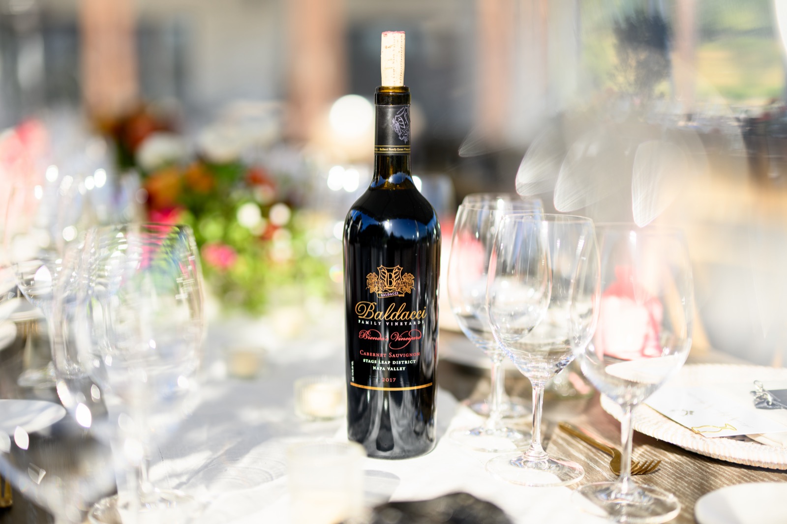 Corked bottle of Baldacci Cabernet Sauvignon among wine glasses on a set table in Napa Valley