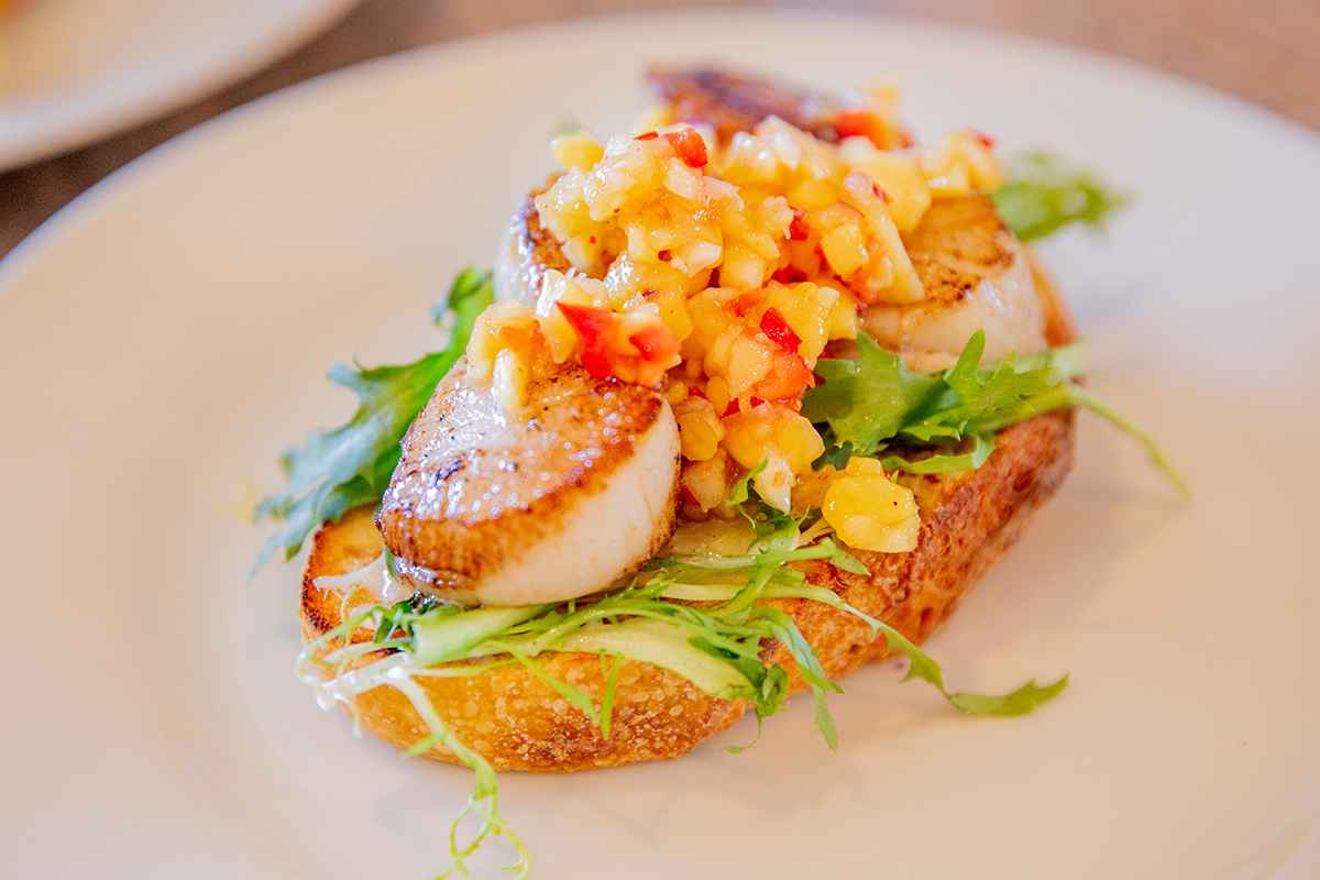 a piece of toast with pan-seared lobster